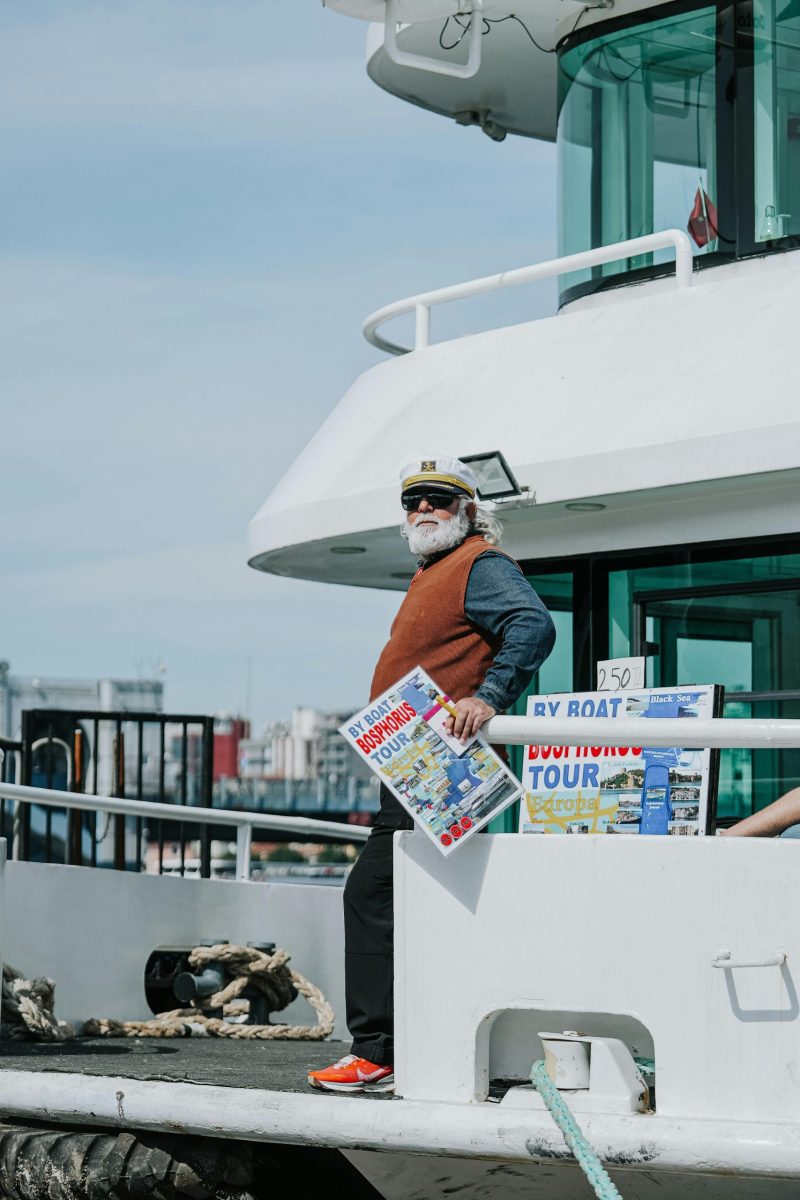 Tour guide on deck promoting Toronto waterfront boat tours on a sunny day.